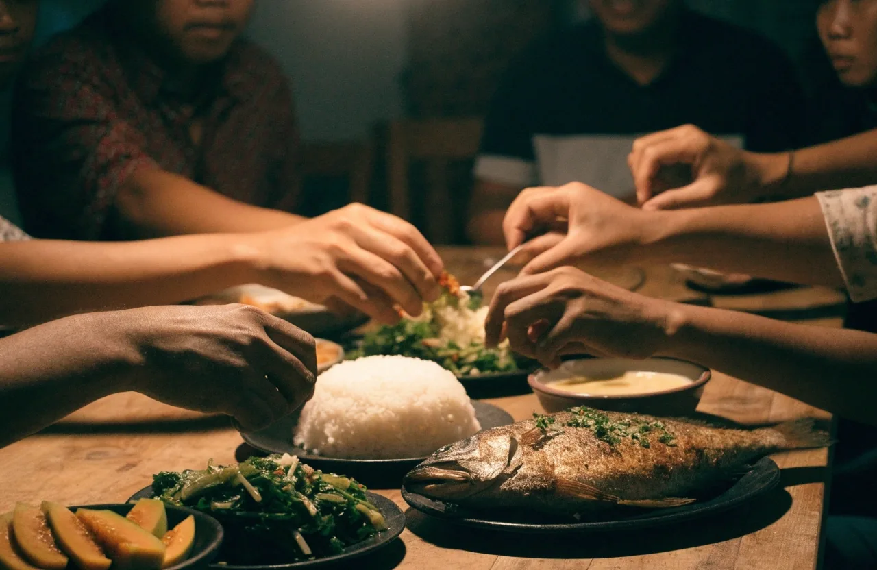 Makan malam sederhana berisi nasi, sayur, ikan, dan buah di meja keluarga